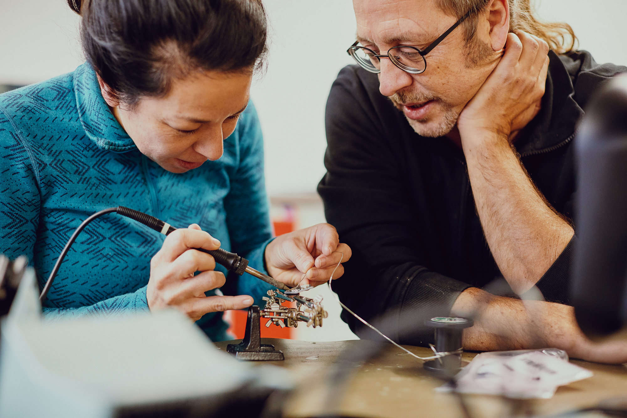 Fotografie einer Frau, die im MakerSpace ein elektronisches Bauteil verlötet. 